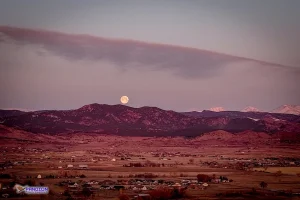 Photo taken by Pandion Property Inspections, LLC using a drone of full moon setting over Rocky Mountains